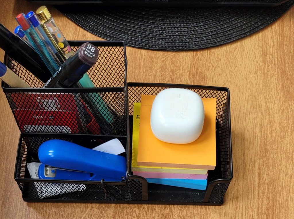 Organizador de escritorio con notas adhesivas y bolígrafos.